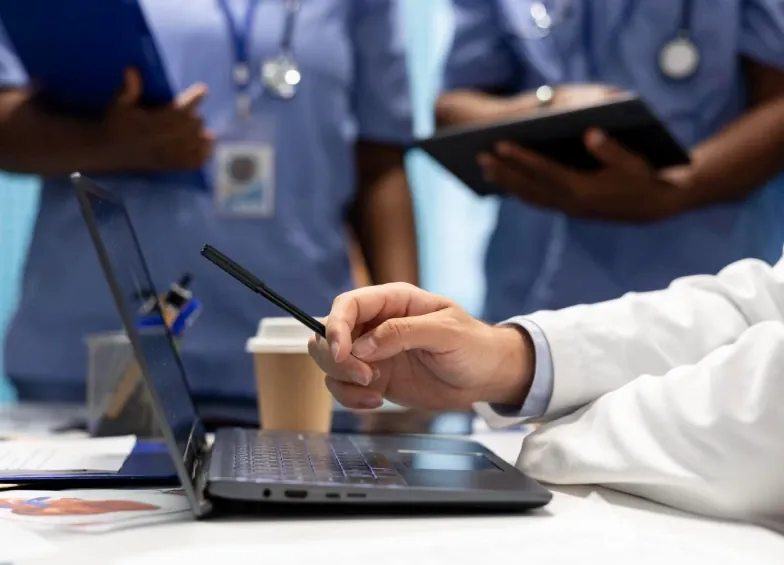 Profissionais de saúde revisam dados em um notebook