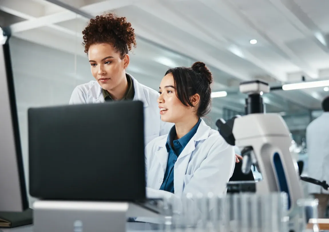Profissionais de laboratório trabalham juntas diante do computador